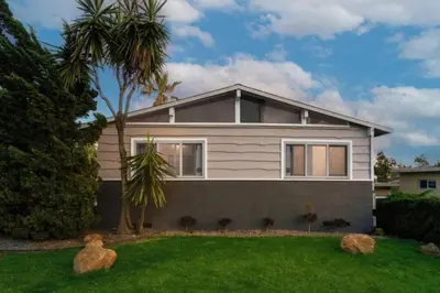 a house with a palm tree in the yard at Remodeled Boho 2 Bed Near Zoo and Downtown in San Diego