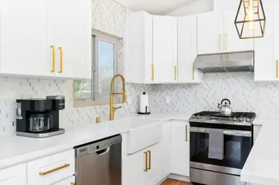 a kitchen with white cabinets and a stove top oven at Remodeled Boho 2 Bed Near Zoo and Downtown in San Diego