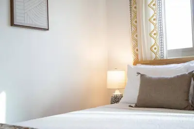 a bedroom with a bed with a white bedspread and a lamp at Remodeled Boho 2 Bed Near Zoo and Downtown in San Diego