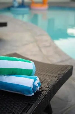 three towels sitting on a table next to a pool at 15 min to San Diego! Walk to Trolley in El Cajon