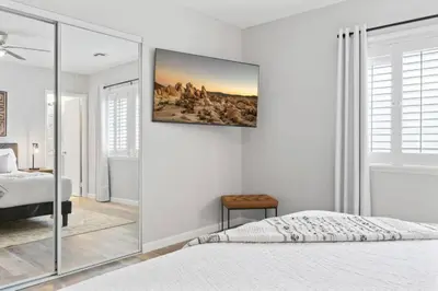 a bedroom with a bed and a painting on the wall at Relax and Play Pool Table, Hot Tub and Mini Golf Fun! in La Mesa