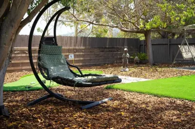 a swing sitting in a yard next to a tree at Relax and Play Pool Table, Hot Tub and Mini Golf Fun! in La Mesa