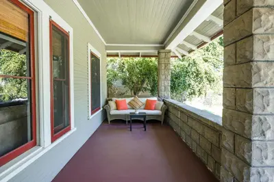 an outdoor porch with a couch and a table at 1907 Stone House - King Bed, Office, Crib, Toys in San Diego