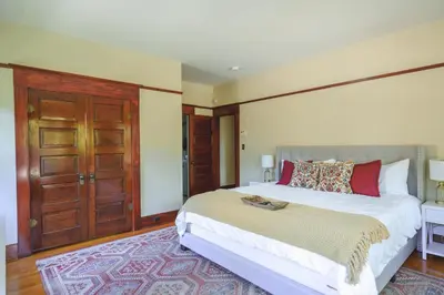 a bedroom with a large bed and a wooden door at 1907 Stone House - King Bed, Office, Crib, Toys in San Diego