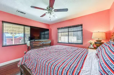 a red bedroom with a bed and a ceiling fan at Spring Valley Family Home 13 Mi to San Diego! in Spring Valley