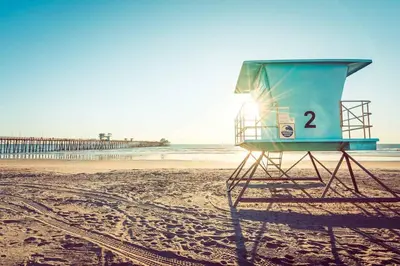 a life guard stand on a beach with the ocean at Shabby Chic Oceanside King & 2 Queen bed Pool GYM in Oceanside