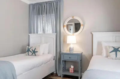 a white bedroom with two beds and a mirror at Pacific Beach Bungalow Just Steps to Beach in San Diego