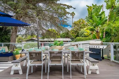 a patio with a table and chairs and an umbrella at Outdoor Haven with Spa Walk to La Jolla Shores Beach in San Diego