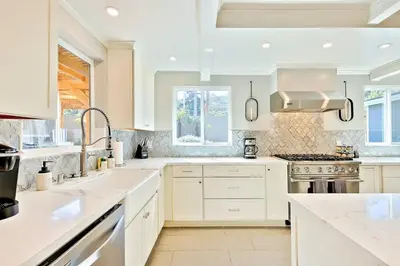 a kitchen with white cabinets and a stove top oven at Outdoor Haven with Spa Walk to La Jolla Shores Beach in San Diego