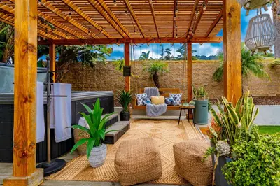 a patio with a wooden pergola with furniture and plants at Outdoor Haven with Spa Walk to La Jolla Shores Beach in San Diego