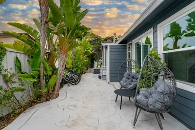 a patio with two chairs and a house at Outdoor Haven with Spa Walk to La Jolla Shores Beach in San Diego