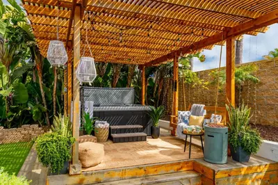 a pergola with a bench and chairs on a patio at Outdoor Haven with Spa Walk to La Jolla Shores Beach in San Diego