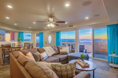 a living room with a large couch and a dining room at Aloha Breeze 1 in San Diego