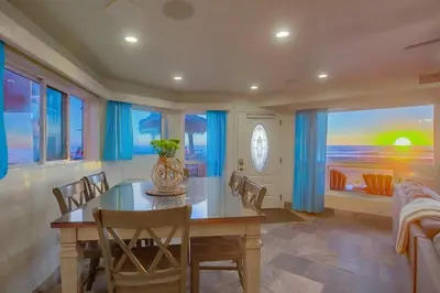 a dining room with a table and chairs and a painting at Aloha Breeze 1 in San Diego