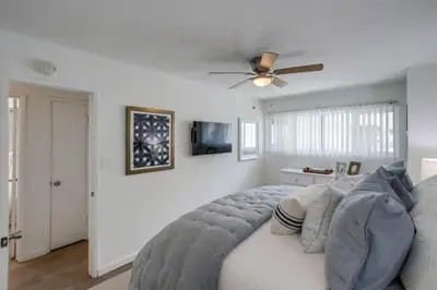 a bedroom with a bed with a ceiling fan at Avalon Beach 2 in San Diego