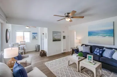 a living room with a blue couch and a ceiling fan at Avalon Beach 2 in San Diego