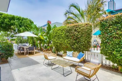 a patio with chairs and tables and a fence at Avalon Beach 2 in San Diego