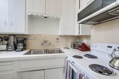 a white kitchen with a sink and a stove at Avalon Beach 2 in San Diego