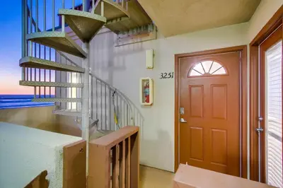 a hallway with a spiral staircase and a red door at Aqua in San Diego