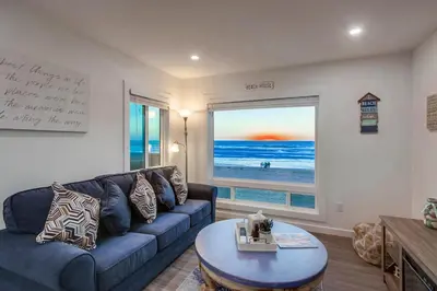 a living room with a blue couch and a large window at Aqua in San Diego