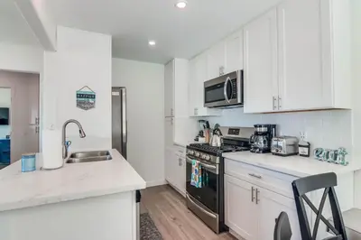 a kitchen with white cabinets and a black stove top oven at Aqua in San Diego