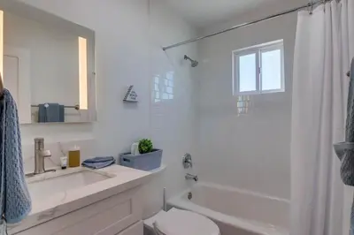 a white bathroom with a toilet and a sink at Aqua in San Diego