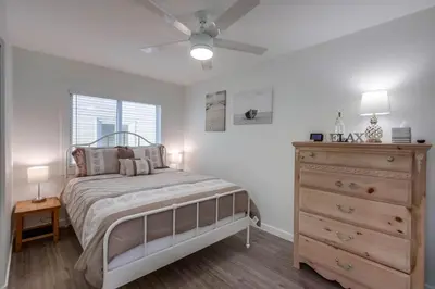 a bedroom with a bed with a dresser and a ceiling fan at Aqua in San Diego
