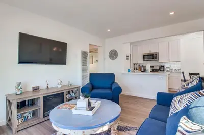 a living room with two blue chairs and a tv at Aqua in San Diego