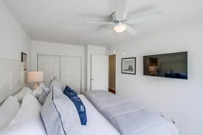 a bedroom with a bed with pillows and a ceiling fan at Avalon Beach 4 in San Diego