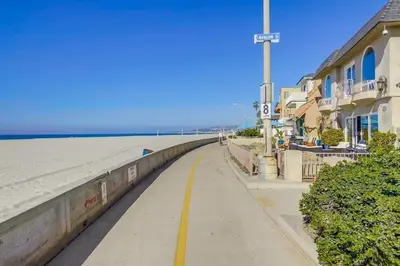 a sidewalk next to a beach next to a building at Avalon Beach 4 in San Diego
