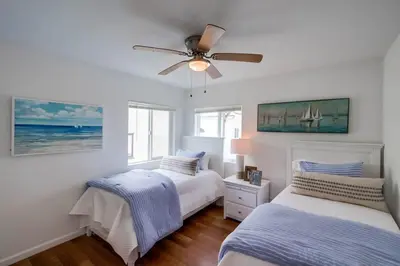 a bedroom with two beds and a ceiling fan at Avalon Beach 4 in San Diego