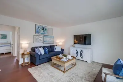 a living room with a blue couch and a tv at Avalon Beach 4 in San Diego