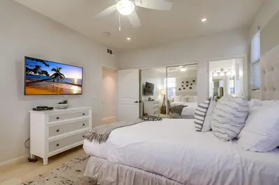 a bedroom with a large white bed and a mirror at Aloha Breeze 2 in San Diego