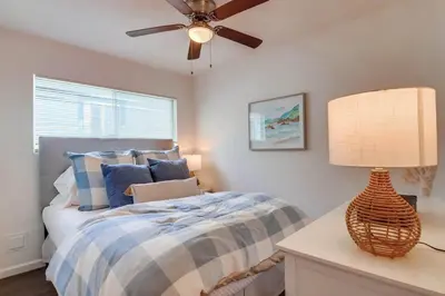 a bedroom with a bed and a ceiling fan at Avalon Beach 1 in San Diego