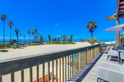 a balcony with a view of the beach and palm trees at Jetty View 2 in San Diego