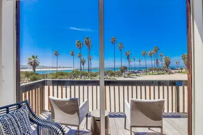 a balcony with a view of the beach and palm trees at Jetty View 2 in San Diego