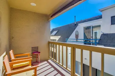 a balcony with a wooden bench and a building at Bay Style 2 in San Diego