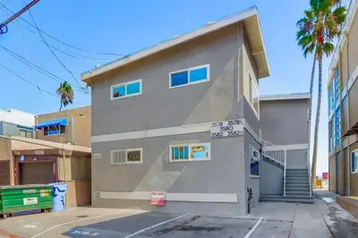 a gray building with blue windows on a street at Bayside 5 in San Diego