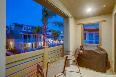 a balcony with two chairs and a window with a view at Bayside Cove 1 in San Diego