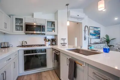 a kitchen with white cabinets and a sink at Bayside Cove 2 in San Diego