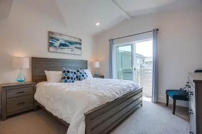 a bedroom with a large bed and a sliding glass door at Bayside Cove 2 in San Diego