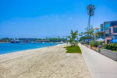 a sandy beach with palm trees and buildings at Bayside Cove 2 in San Diego