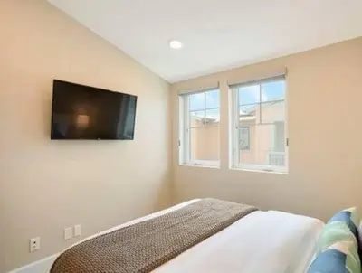 a bedroom with a flat screen tv on the wall at Bayside Cove 3 in San Diego