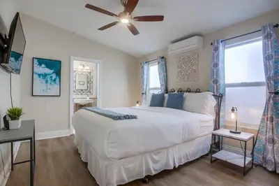 a bedroom with a white bed and a ceiling fan at Beach & Bay in San Diego