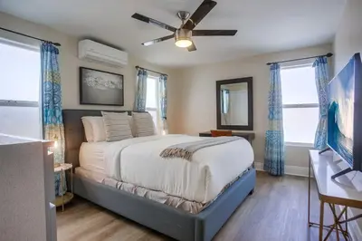 a bedroom with a large bed with a ceiling fan at Beach & Bay in San Diego