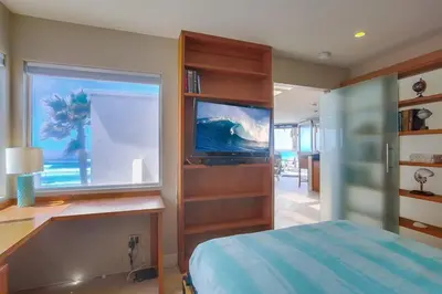 a bedroom with a bed and a desk and a window at Beachside 2 in San Diego