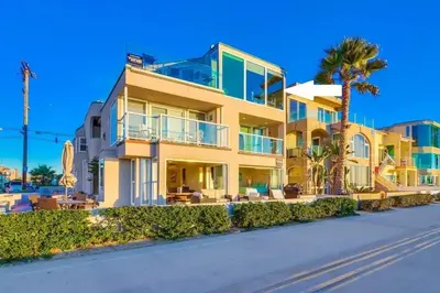 a large yellow building with palm trees in front of it at Beachside 2 in San Diego