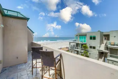 a balcony with chairs and a view of the beach at Beach Break 1 in San Diego