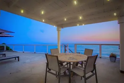 a table and chairs on a balcony with the ocean at Beacons in Encinitas