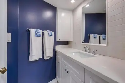 a bathroom with a white sink and a blue wall at Beacons in Encinitas